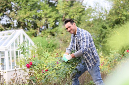 Worker wearing protective gear operating a hedge trimmer